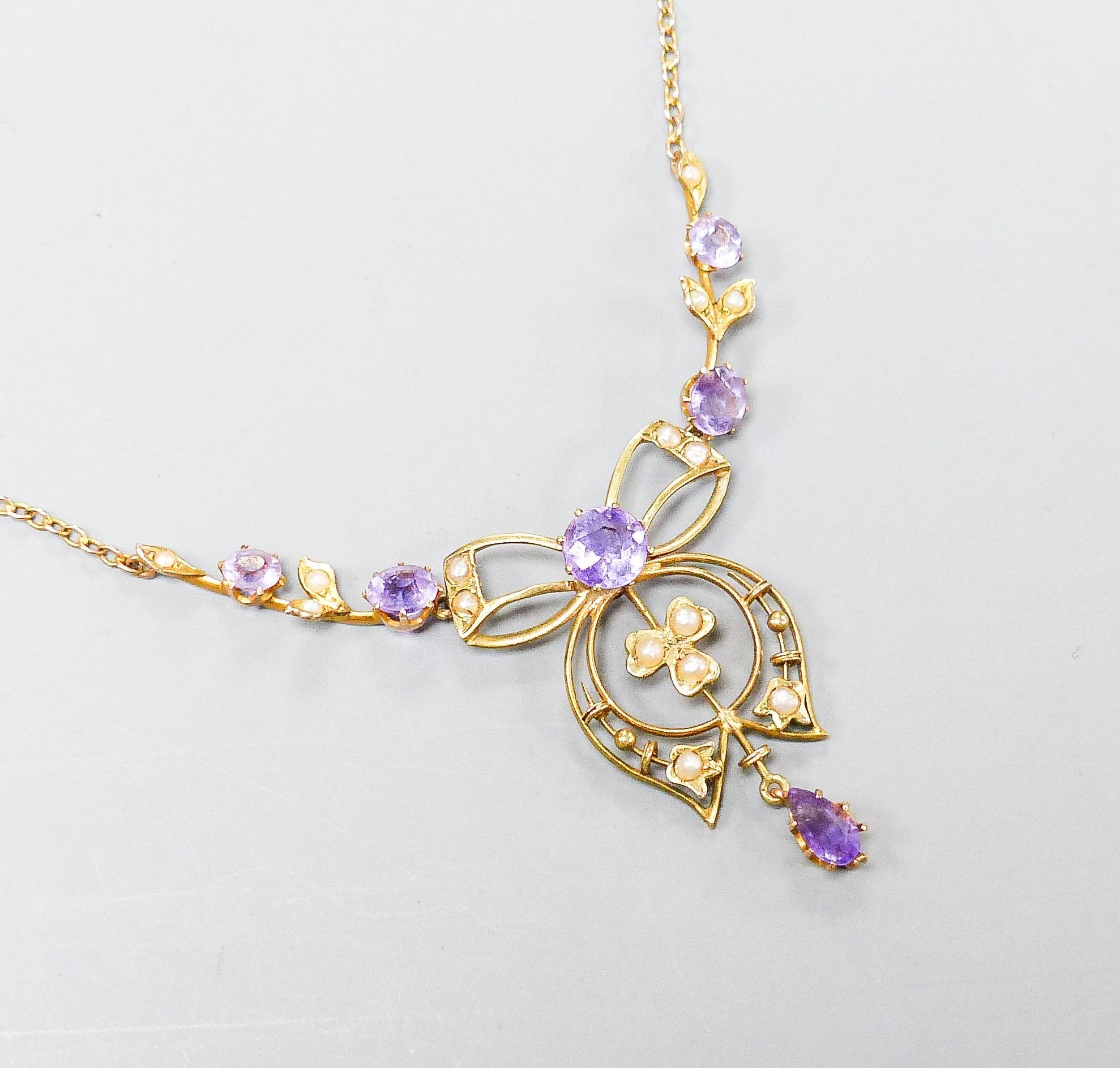 An Edwardian 9ct, amethyst and seed pearl set drop pendant necklace, 44cm